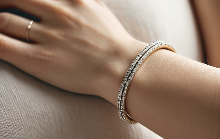 **
* **Prompt:** Close-up photo of a slender wrist adorned with a delicate white gold bracelet. Focus on the subtle sparkle and the bracelet's fine chain. Soft, diffused lighting to emphasize elegance. Background: blurred neutral tones.
**